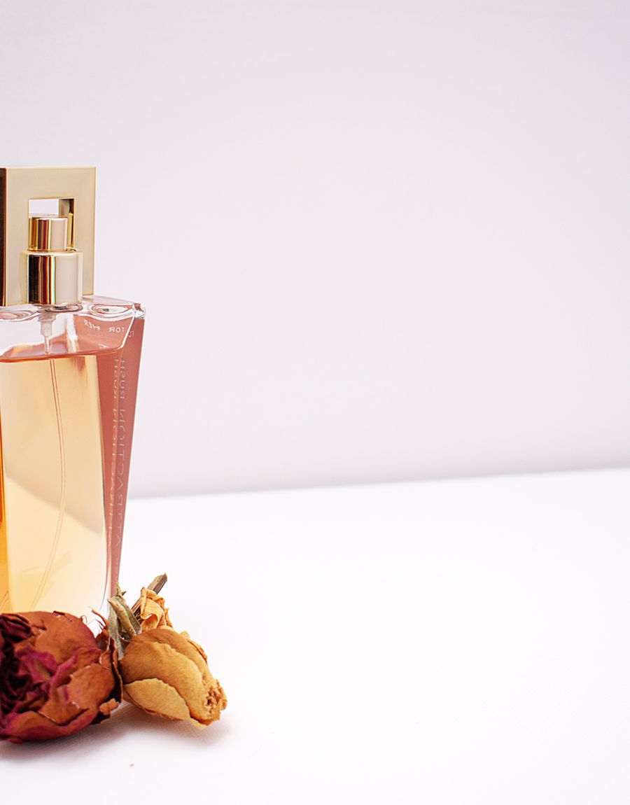 Perfume bottle with a gold cap and dried rose